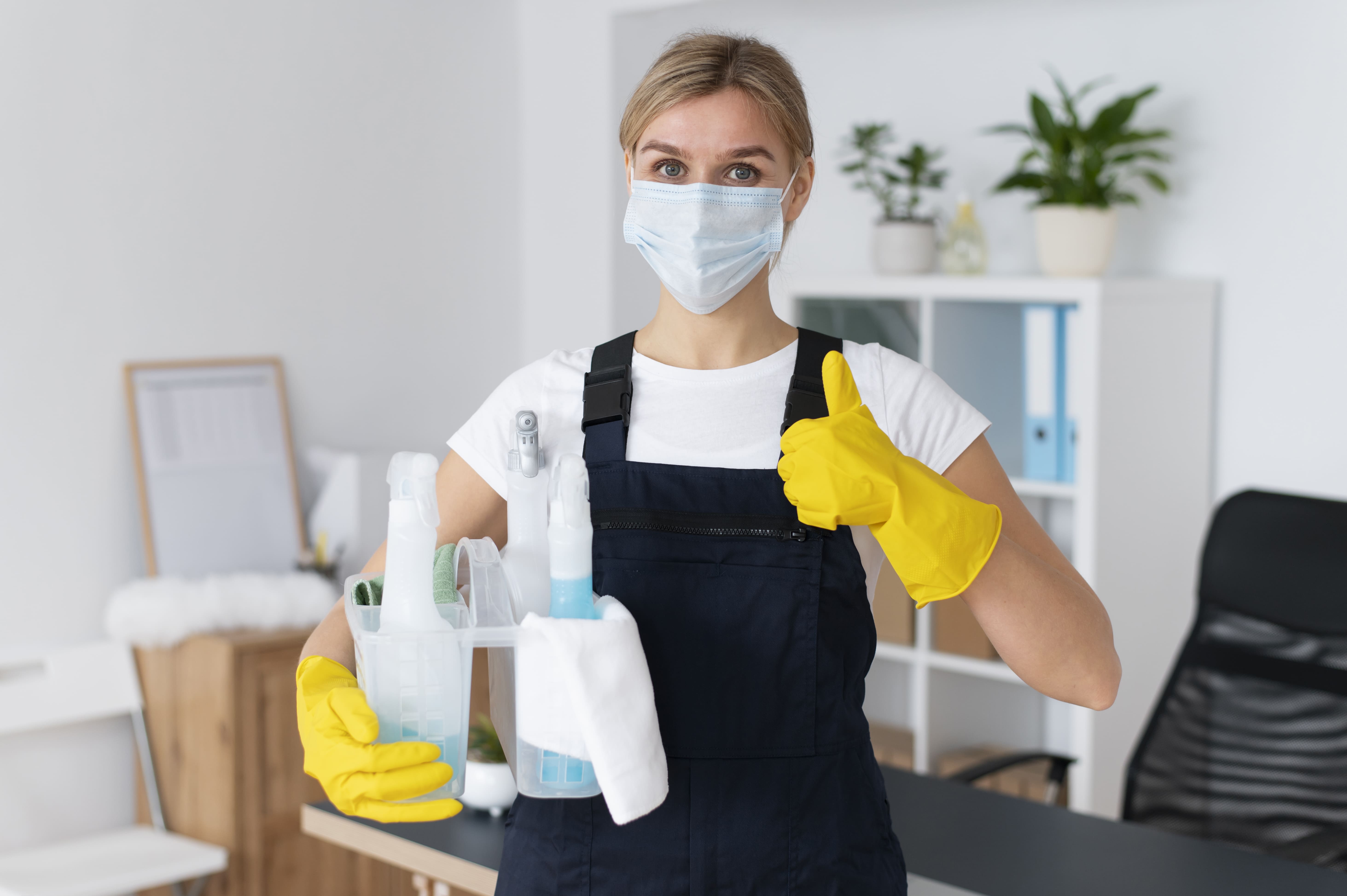 About Us 2 A professional Kazi Cleaning Company staff member in Kuwait wearing a safety mask and gloves, holding a cleaning kit.